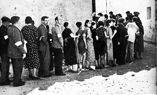 Habitantes de Medelln haciendo cola para proveerse de alimentos.(Foto: Guas Visual es de Espaa. EXTREMADURA, pg. 23).